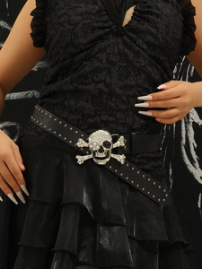 Close-up of black punk belt with silver rivets and rhinestone skull buckle on model