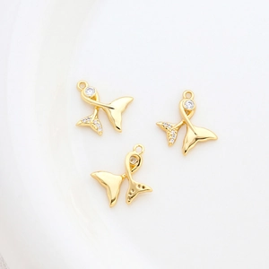 Detailed view of three 14k gold plated mermaid tail pendants with sparkling zircon stones