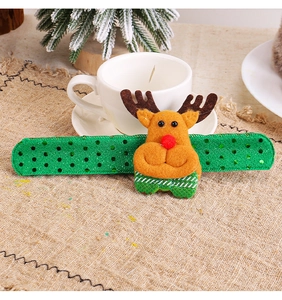 Close-up of a festive green sequin slap bracelet featuring a cute plush reindeer character