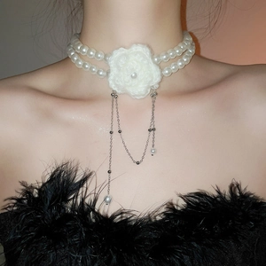 Gros plan sur le collier de perles rétro avec fleur tricotée et glands argentés