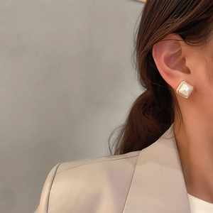 Elegant geometric square pearl stud earrings with gold plating on a fashion model