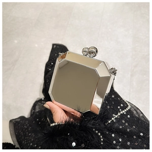 Detailed close-up of octagonal silver mirror evening bag with pearl clasp and chain strap