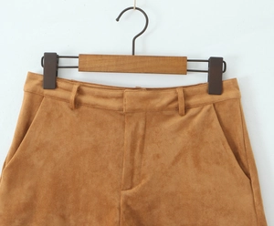 Detail shot of tan suede shorts waistband with belt loops and quality stitching on a hanger