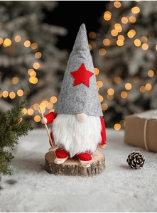Detail of Christmas ski gnome with felt hat and wooden poles on a warm festive background