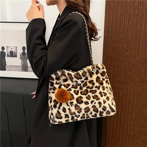 Chic leopard print faux fur handbag with gold chain strap and decorative pompom detail