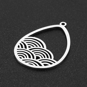 Macro detail of silver stainless steel water drop pendant with hollow wave pattern