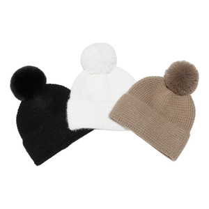 Three-piece knitted beanie set in black white and brown with faux fur pom-poms
