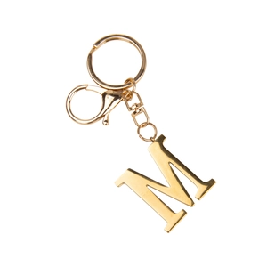 Detailed view of the gold letter M keychain with lobster clasp on a white background