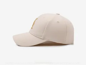 Side view of beige baseball cap featuring golden embroidery and six-panel structure