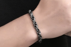 Close-up of vintage oxidized titanium steel bracelet with thick twisted chain on wrist