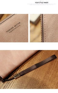 Close-up of pink long wallet with woven wrist strap and fine leather texture detail