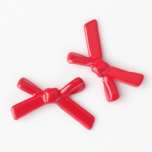 Detailed close-up of two red bow-shaped alloy beads with smooth painted finish for jewelry