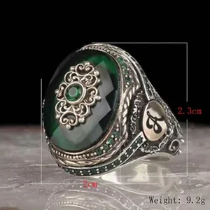 Vintage silver-tone ring with oval green gemstone and intricate filigree details