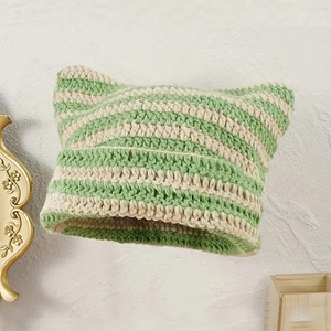 Detail of green and white striped knit beanie with pointed cat ear design