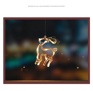 Detail of warm yellow LED Christmas hanging light in a reindeer silhouette for window decor