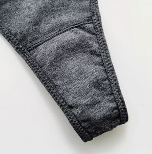 Detail of double-needle stitching on dark grey cotton thong showing fabric texture