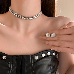 Detailed view of silver rhinestone choker necklace and square stud earrings set on model