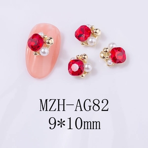 Makroansicht von 9x10mm roten Nagelschmuck-Strasssteinen mit Perlen und Goldperlen
