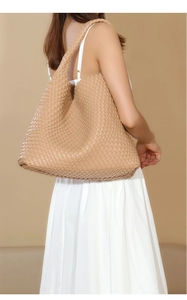 Detail shot of the large beige woven leather tote bag with wide shoulder strap