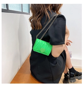 Macro view of bright green silicone heart mini bag with gold chain and quilted texture
