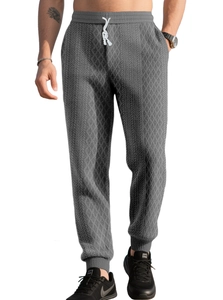 Close-up of men's dark grey waffle knit joggers with diamond texture and white drawstring