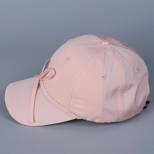 Detail of pink satin baseball cap featuring a delicate bow and light breathable fabric