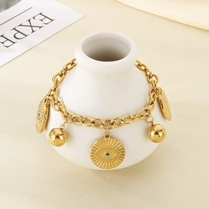 Close-up of golden stainless steel bracelet with blue evil eye pendant and metal ball charm