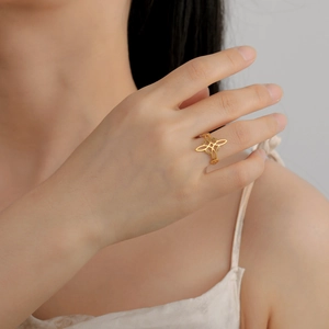 Close-up of a gold minimalist witch knot ring on model finger showing elegant lace design