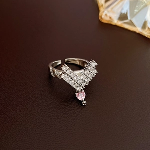 Detail of silver V-shaped ring with pink heart pendant and pavé zircons on leather