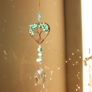 Detail of tree of life suncatcher with heart crystal prism and rainbow reflections