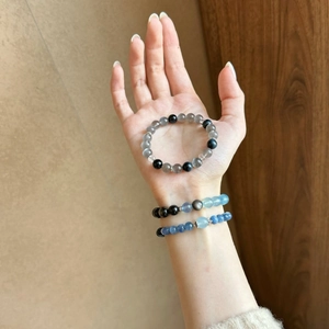 Moonstone and obsidian beaded bracelet with hollow metal spacers on a woman's wrist
