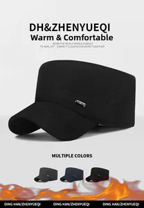 Detail view of winter flat top cap featuring thick fabric and metal decorative buckle