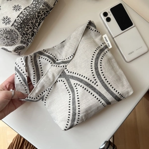 Detail of cotton linen tote bag featuring black geometric patterns and simple wish label