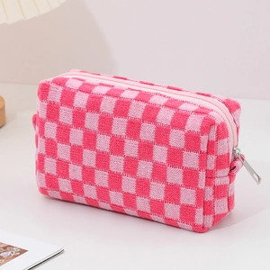 Pink checkered knitted cosmetic bag with zipper closure on a white minimalist surface
