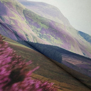 Detailed close-up showing woven fabric texture and mountain scenery print on tapestry