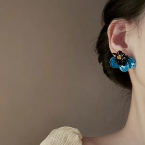 Detailed side view of a luxury blue flower earring with 3D petals and metallic stamen