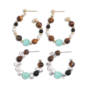 Vintage hoop earrings set with tiger eye, faux pearls and colorful beads on white surface