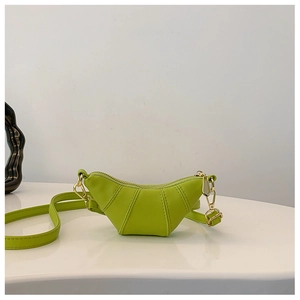 Detail view of fruit green horn-shaped crossbody bag with gold hardware and leather texture