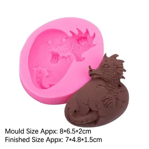 Pink silicone mold for Easter dinosaur egg shape and brown fondant model on white background