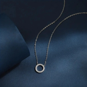 Close-up of a minimalist silver circle pendant necklace with pavé-set shimmering crystals