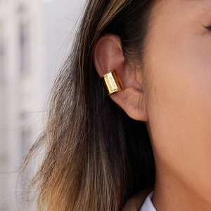 Polished 18K gold-plated wide cuff earring with beaded edge texture on model