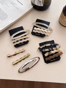 Detail of tortoise shell and ivory acetate hair clips on elegant aesthetic background