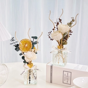 Detail of reed diffuser set with preserved orange slices, sola flowers, and silk ribbon