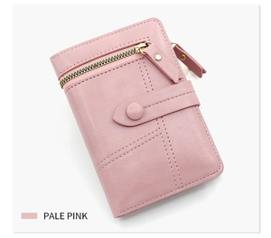 Detail of pale pink PU leather trifold wallet with decorative stitching and buckle closure