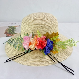 Detail view of straw sun hat with colorful fabric floral accents and black ribbon ties