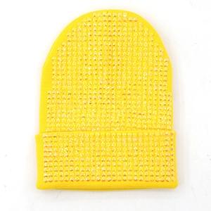 Dettaglio del berretto in maglia giallo acceso con paillettes colorate brillanti
