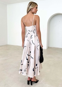 Detail of light pink floral maxi dress showing open back design and silk-like drape