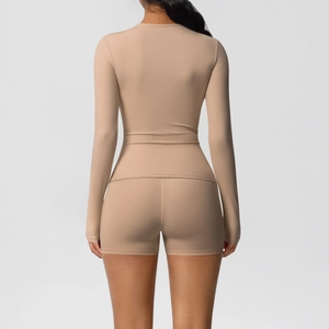 Close-up back view of nude long-sleeve yoga top and high-waist fitness shorts set