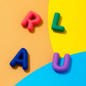 Macro view of colorful 3D alphabet letter pendants in pink, green, blue and purple