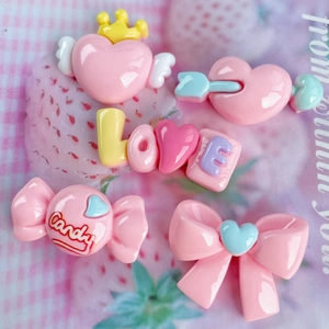 Pink resin charms set with hearts, bows and LOVE candy shapes on strawberry fabric